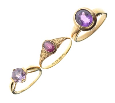 Lot 30 - Three yellow metal dress rings set amethyst-coloured stones