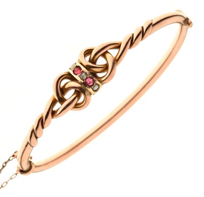 Lot 47 - Yellow metal (9ct 'rose gold'), ruby and tinted split pearl snap bangle