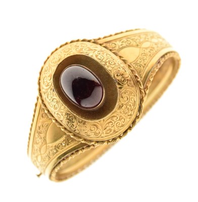 Lot 22 - A Victorian garnet set gold hinged bangle