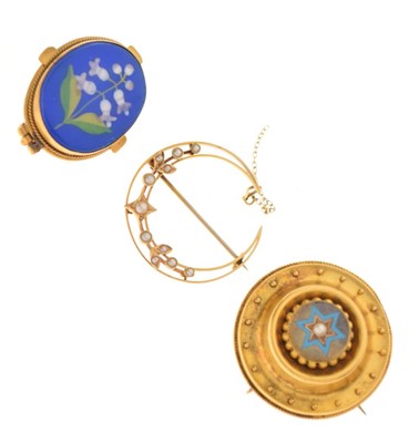 Lot 31 - Crescent shaped brooch set seed pearls, stamped '15ct', a yellow metal target brooch, and a floral decorated brooch (3)