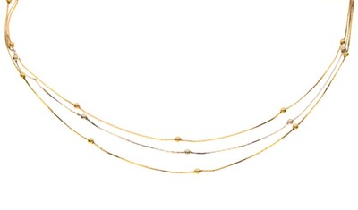 Lot 61 - Three row two-colour necklace with ball spacers, stamped '750'