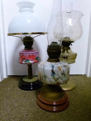 Lot 752 - Group of three early 20th century cast metal and glass oil lamps