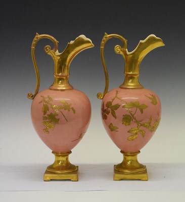 Lot 397 - Pair of pink ground gilded ceramic ewers