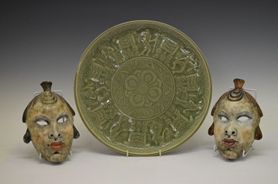 Lot 744 - Pair of ceramic wall hanging painted face masks and Thai green glazed plate