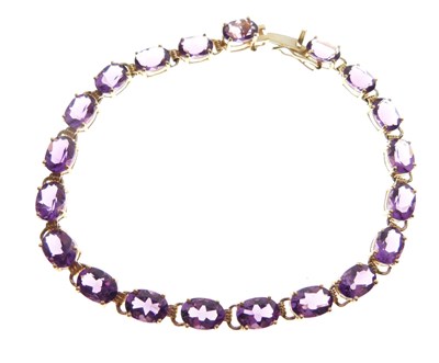 Lot 87 - Yellow metal (14K) amethyst-set 'riviere' bracelet
