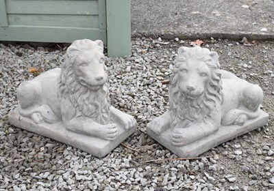 Lot 734 - Pair of composite gardens statues recumbent lions