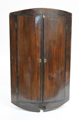 Lot 651 - George III oak and mahogany bowfront corner cupboard