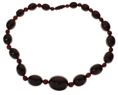 Lot 51 - 'Cherry amber' coloured bead necklace