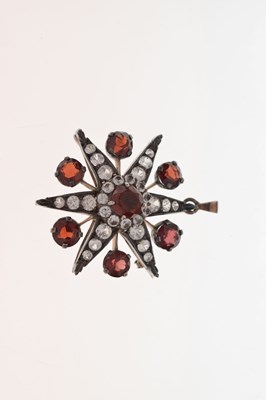Lot 28 - Victorian garnet and white stone pendant brooch, starburst