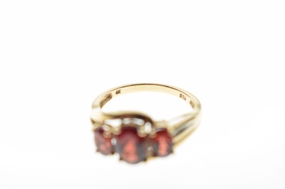 Lot 69 - Three-stone garnet crossover ring
