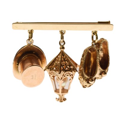 Lot 106 - Bar brooch, stamped '750' suspended three charms