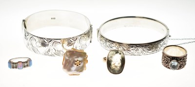 Lot 182 - Two silver hinged bangles and four gem-set rings