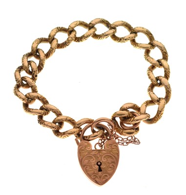 Lot 173 - Engraved decorated curb link yellow metal bracelet, with '9ct' heart-shaped padlock clasp