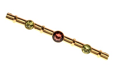 Lot 84 - Peridot and garnet '9ct' yellow metal bar brooch