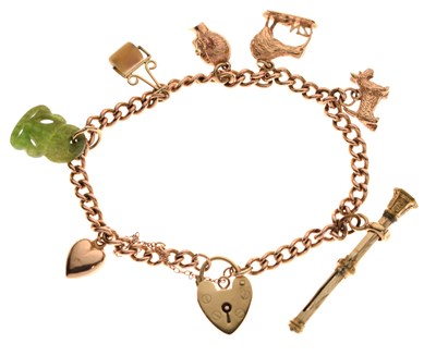 Lot 170 - Curb link yellow metal charm bracelet with 9ct gold heart-shaped padlock clasp