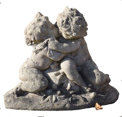 Lot 561 - Composition stone garden ornament figure group of two cherubs kissing