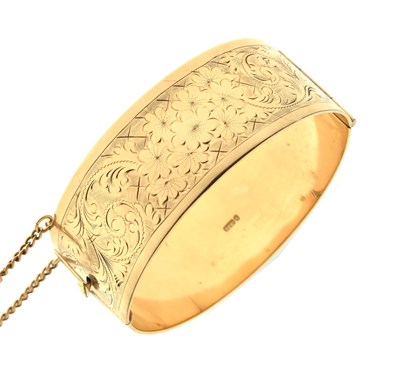 Lot 129 - 9ct gold part foliate engraved hinged bangle