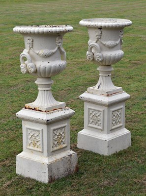 Lot 209 - Pair of white-painted cast iron garden urns with pedestals