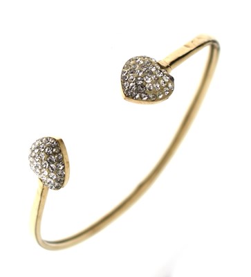Lot 194 - Yellow metal torque bangle, the heart-shaped terminals set with crystals