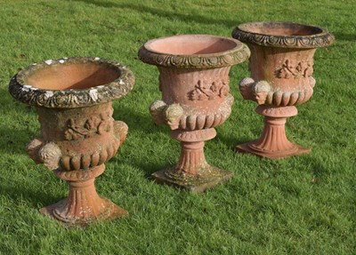 Lot 529 - Three terracotta coloured composition garden urns