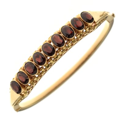 Lot 87 - Garnet 18ct yellow gold hinged bangle