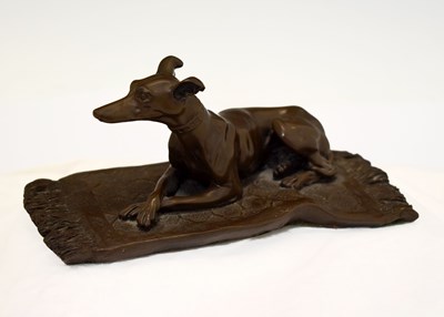 Lot 328 - Cold cast bronzed resin model of recumbent whippet or greyhound