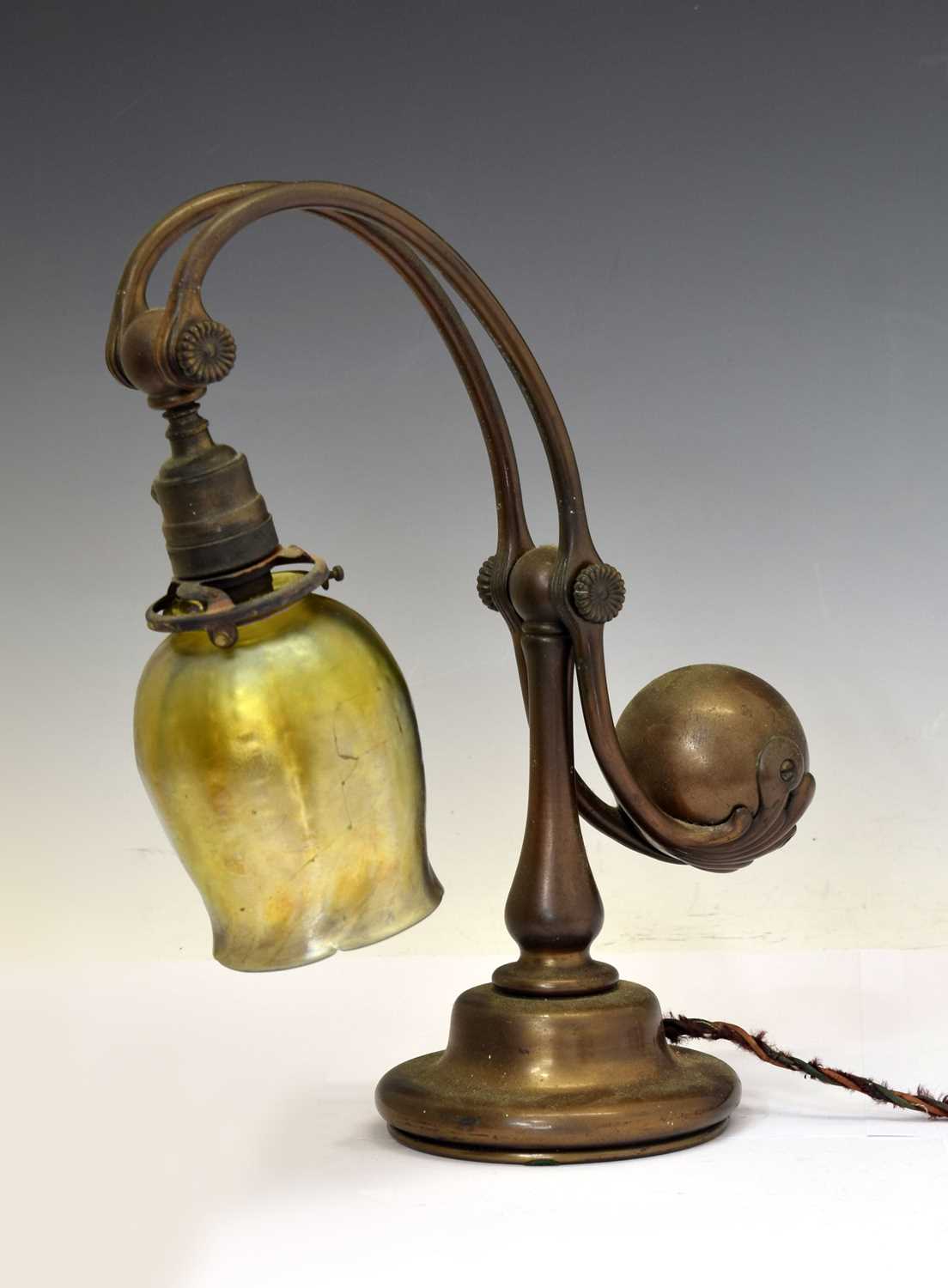 Lot 266 - Tiffany Studios, a counter-balance patinated bronze desk lamp with ‘favrile’ glass shade