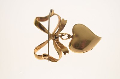 Lot 45 - Yellow metal (750) and red enamel decorated heart-shaped locket on a tied bow brooch fitting