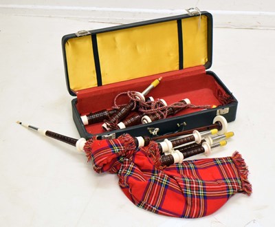 Lot 437 - A cased set of bagpipes with red tartan fabric