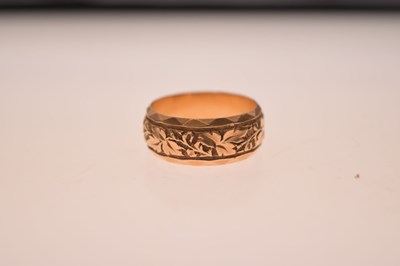 Lot 50 - 18ct gold wedding band with foliate decoration