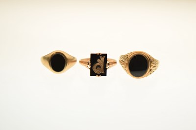Lot 24 - Two 9ct and black onyx rings together with a similar yellow metal example