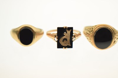 Lot 24 - Two 9ct and black onyx rings together with a similar yellow metal example