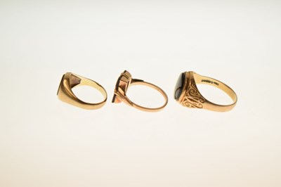 Lot 24 - Two 9ct and black onyx rings together with a similar yellow metal example