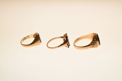Lot 24 - Two 9ct and black onyx rings together with a similar yellow metal example