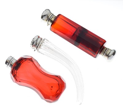 Lot 208 - Two silver-topped cranberry glass perfume/scent bottles together with a clear glass example (3)