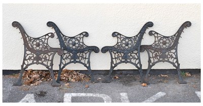 Lot 754 - Two pairs of cast metal garden bench ends having side circular Lion head motifs