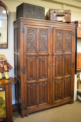 Lot 731 - Reproduction heavily carved oak two-door wardrobe