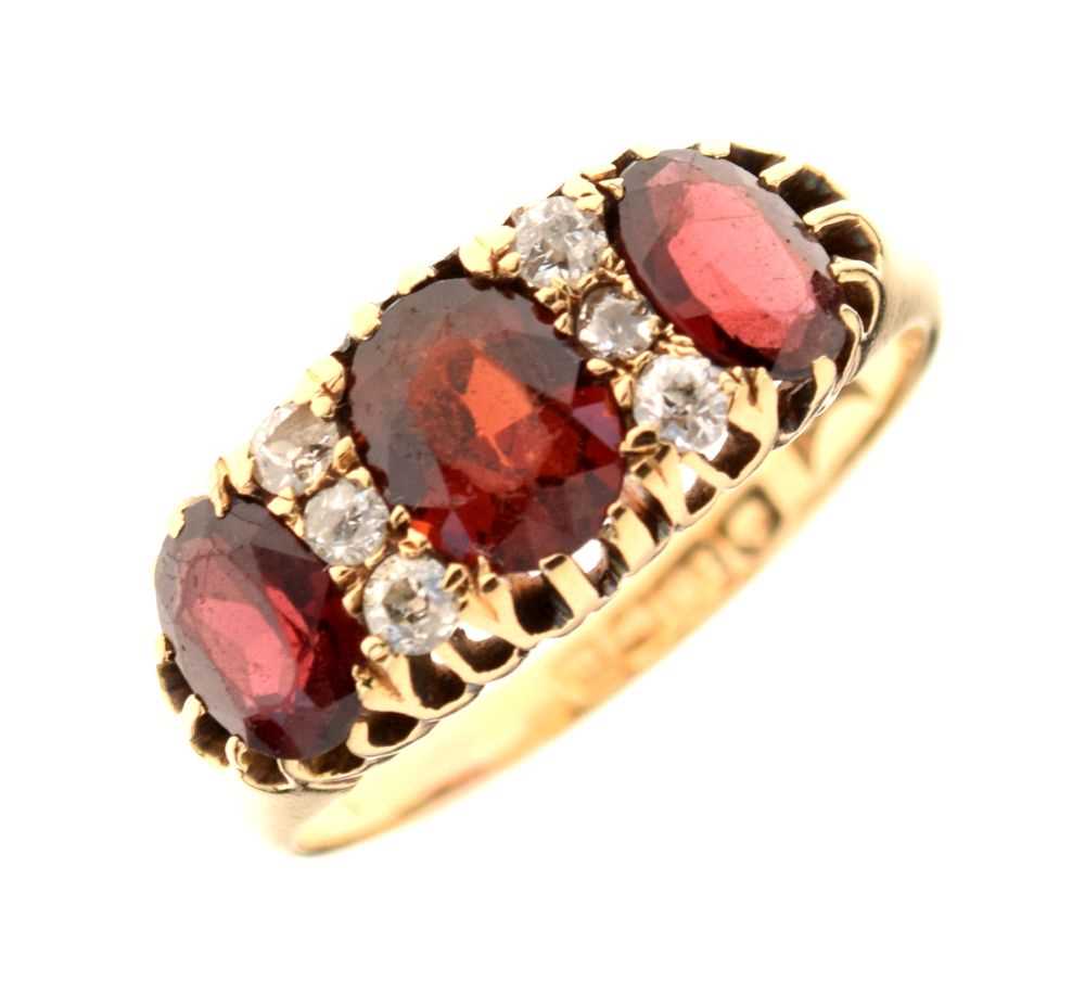 Lot 26 - George V 18ct gold three stone garnet ring