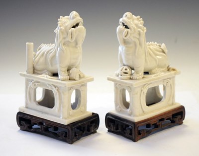 Lot 451 - Two blanc de chine temple lions on wooden stands