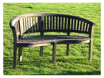Lot 802 - Two-seater teak garden bench of curved form